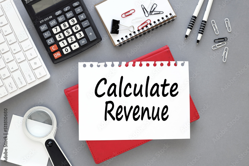 Poster calculate revenue on the desktop is a grey notebook, a white sheet of paper with text.