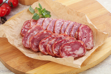 Sliced salami sausages over board