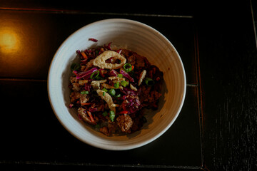 Stir-fry dish on black wood counter