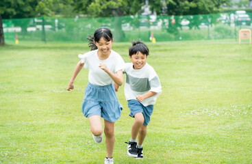 Obraz premium 芝生の公園を走るアジア人の子供