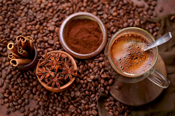 Hot black coffee and coffee beans on the old wooden table