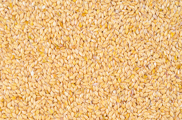 Gold flax seeds texture as background.