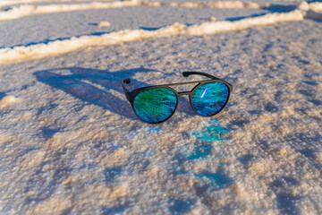 glasses, smartphone in the largest salt flat in Bolivia and the world