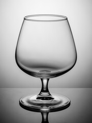 An empty cognac glass stands on a gray table
