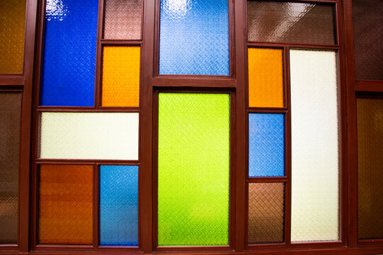 Interior design decorate wooden window and wood door with colorful stained glass background in architecture building at Wat Sangkhatan temple in Bang Phai of Nonthaburi, Thailand