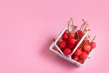 a handful of sweet cherries in a cart, sweet cherry on pink background