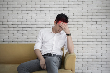 Businessman young asian having a migraine or headache, struggle with dizziness on sitting couch at home