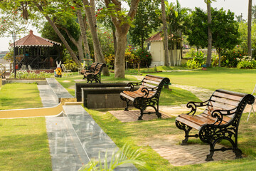 Few wooden river facing benches for relax in the lawn. Selective focus.