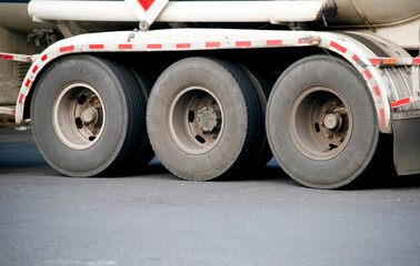 Naklejka na ściany i meble Semi trailer truck wheels on the road