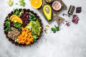 Fototapeta na wymiar Quinoa salad in bowl with avocado, sweet potato, beans on gray background. superfood concept. Healthy, clean eating concept. Vegan or gluten free diet. top view