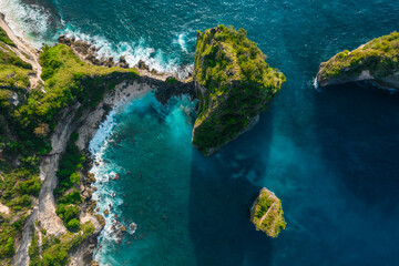 Aerial drone top view shot of rocky beach with cliff. Indian ocean shore. Copy space for text. Nature and travel background. Beautiful natural summer vacation travel concept. Waves splash.