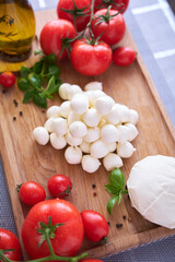 Ingredients for Caprese salad - Mini mozzarella cheese in glass bowl, tomato and basil