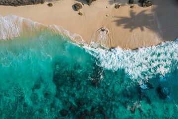 Aerial drone top view shot of rocky beach with cliff. Indian ocean shore. Copy space for text. Nature and travel background. Beautiful natural summer vacation travel concept. Waves and sand. © ImageFlow