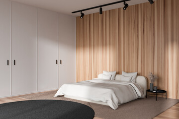 Light bedroom interior with bed and decoration on nightstand. Empty wall