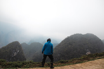 A tourist sightseeing in Dong Van Karst Plateau Geopark in Ha giang Vietnam - obrazy, fototapety, plakaty