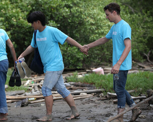 Happy volunteer working , volunteering, charity, cleaning, people and ecology concept - group of happy volunteers with garbage bags cleaning area in park