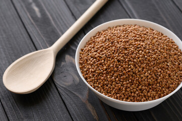 Raw buckwheat on a wooden rustic background.