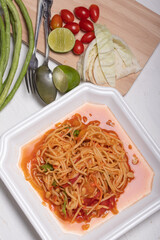 Thai papaya salad in a white plate Popular dishes on a white background