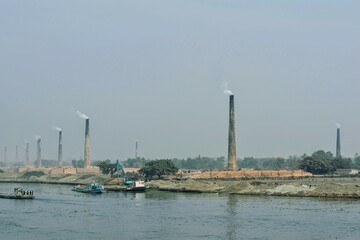 Series of the brick kilns standing by the riverside.