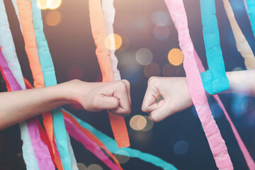 
Close-up shot of a woman and man's hands colliding friendship with rainbow cloth at an equal...