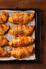 big croissants on a wooden background, top view