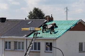 Ouvriers travaillant à l'isolation d'un toit  - obrazy, fototapety, plakaty