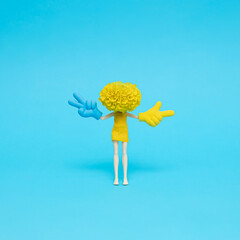 Doll with marigold head showing peace (victory) and showing pointer signs. Creative hand gesture...
