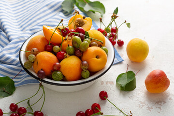 Summer fruits in white bowl pie concept cherry apricots berry