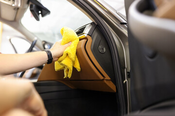 Close-up of male hand cleaning vehicle interior, cleaner washes car leather salon