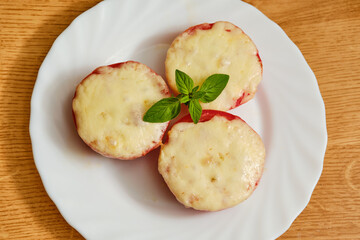 Tomatoes with melted cheese on plate