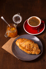 Aromatic morning coffee and croissant with orange jam