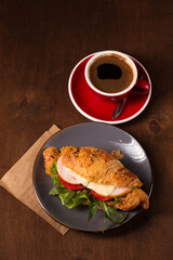 Croissant with turkey and coffee, top view
