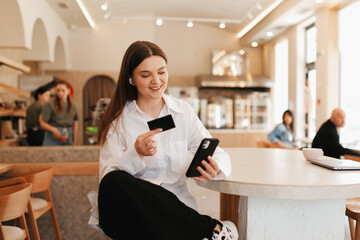 Girl is shopping online in a cafe