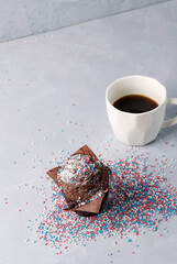 Chocolate cake with white, blue and red pastry sprinkles with a cup of natural coffee