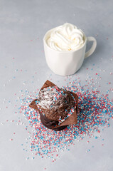 Chocolate muffin sprinkled and whipped cream in a cup