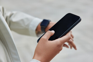 Cropped shot of female hand with electronic wristwatch smartphone searches useful information via...