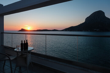 Sunset view of Telendos island in Aegean Sea from hotel balcony. Kalymnos island, Greece.