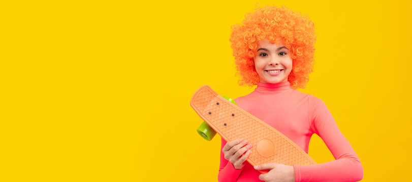 Happy girl scater with orange hair in pink poloneck smile holding pennyboard, skateboarding. Funny teenager child on party, poster banner header with copy space.
