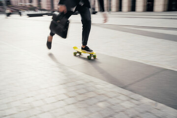 Obraz premium In motion photo, a man on a skateboard goes to the office to work
