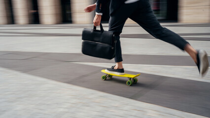 Fototapeta premium In motion photo, a man on a skateboard goes to the office to work