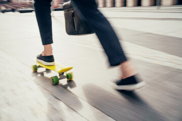 Blurred in motion photo, a man on a skateboard goes to the office
