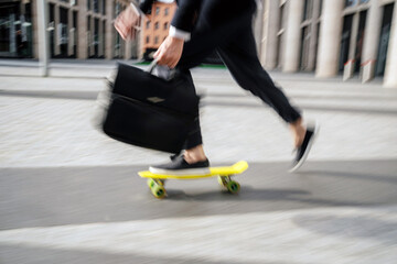 Fototapeta premium Blurred in motion photo, a man on a skateboard goes to the office
