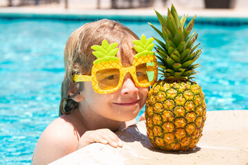 Happy child playing in swimming pool. Summer kids vacation. Little kid boy relaxing in a pool having fun during summer vacation.