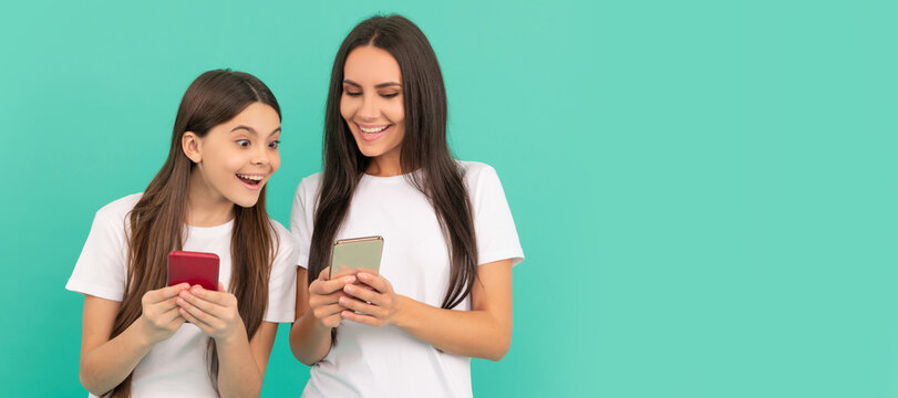 Mother and daughter child banner, copy space, isolated background. shocked mother and daughter chatting on smartphone on blue background. - Powered by Adobe