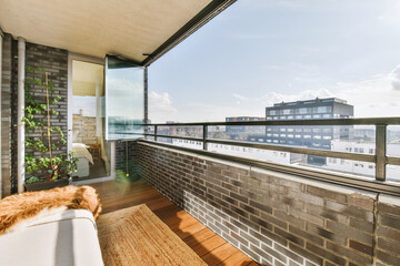 A balcony of a house with glass walls and stylish furniture