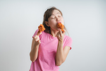Young asian woman holding and eating fries chicken on white background