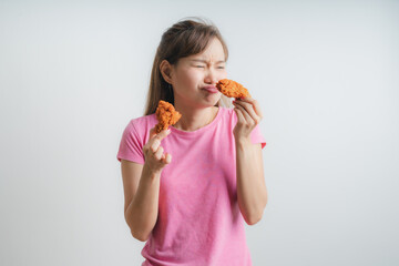 Young asian woman holding and eating fries chicken on white background