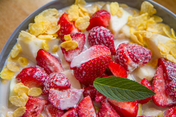 Cornflakes with oat milk and fruit - apple, pear and strawberries decorated with mint leaf