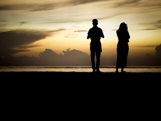 Fototapeta premium Sunrise silhouette couple taking pictures