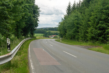 Asphalt road leading to the village. Bavaria, Germany.